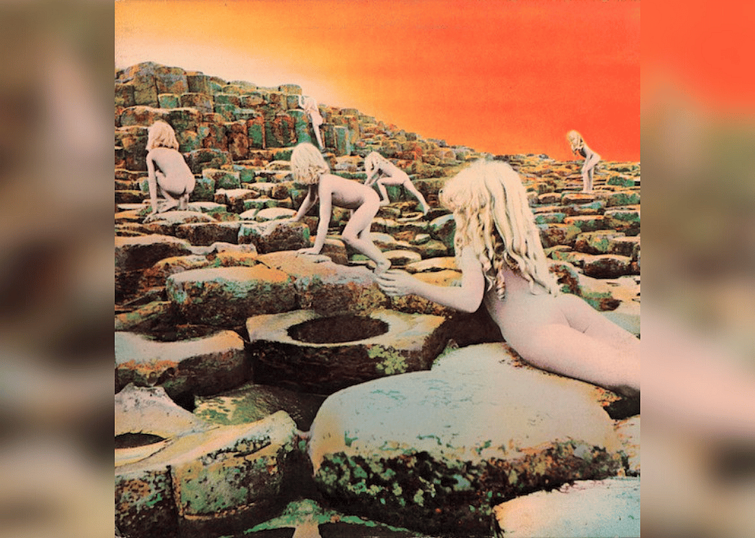 Unclothed kids climbing over stones on a hill. 