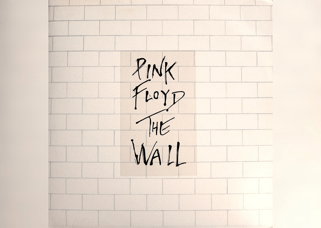 White brick wall with album name in the middle.