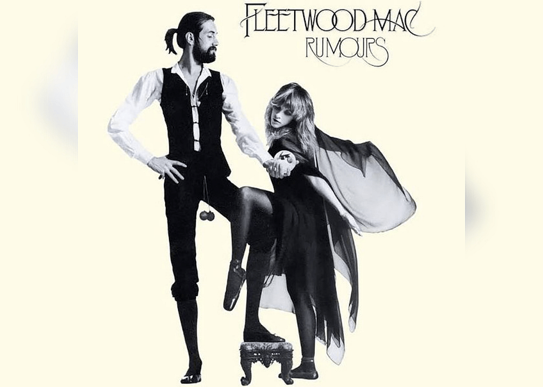 Stevie Nicks and Mick Fleetwood hold hands and look ready to dance.