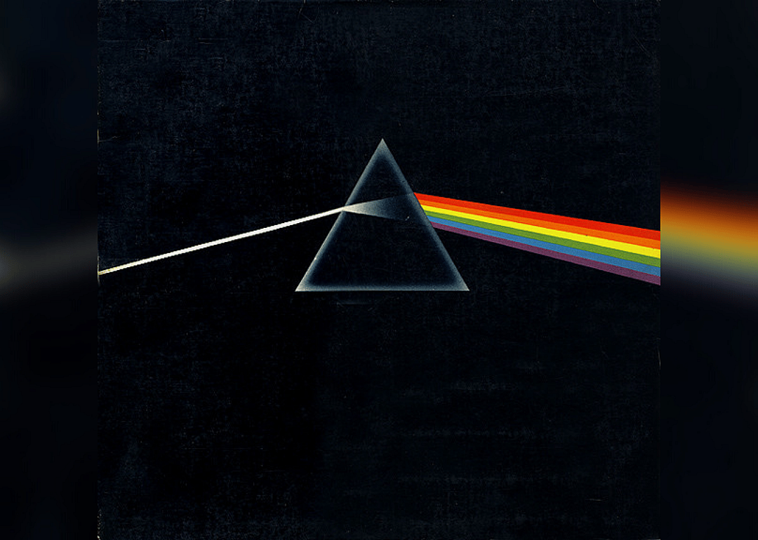 Triangle with rainbow of light coming out one side on black background.