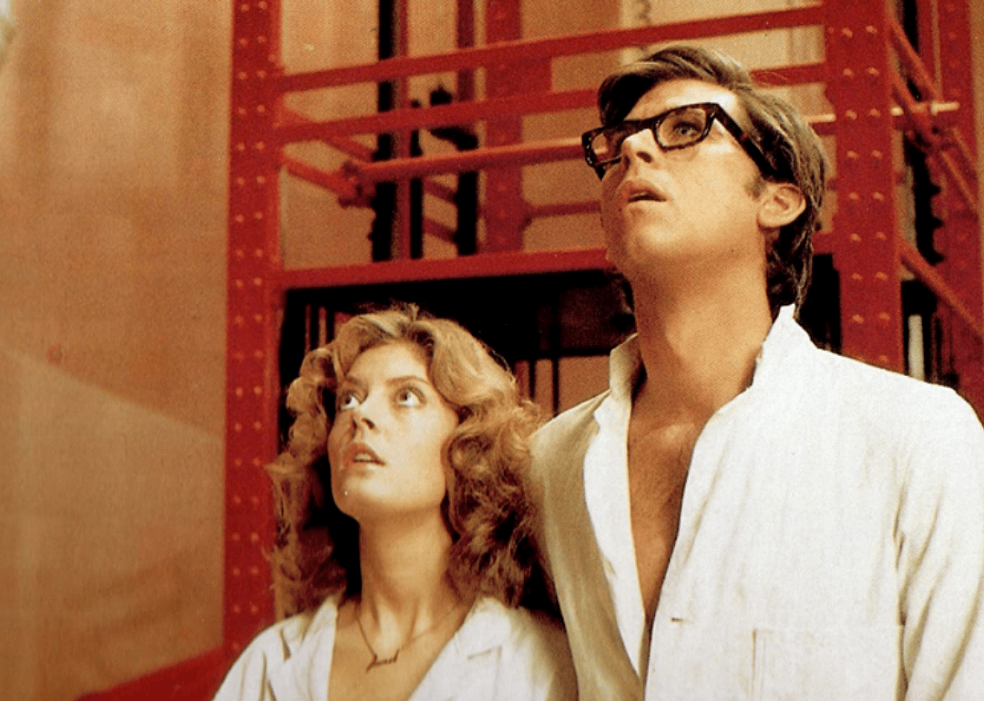 Susan Sarandon and Barry Bostwick stand staring up at something.