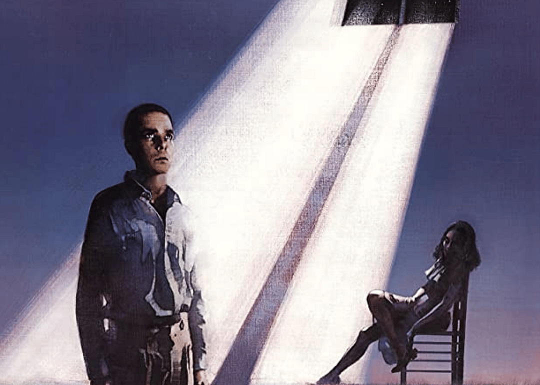 A drawing of a man and a woman in a dark room standing under a sun beam from the ceiling.