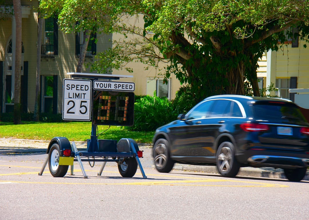 A radar detector shows a passing car's speed limit as it speeds down the road.