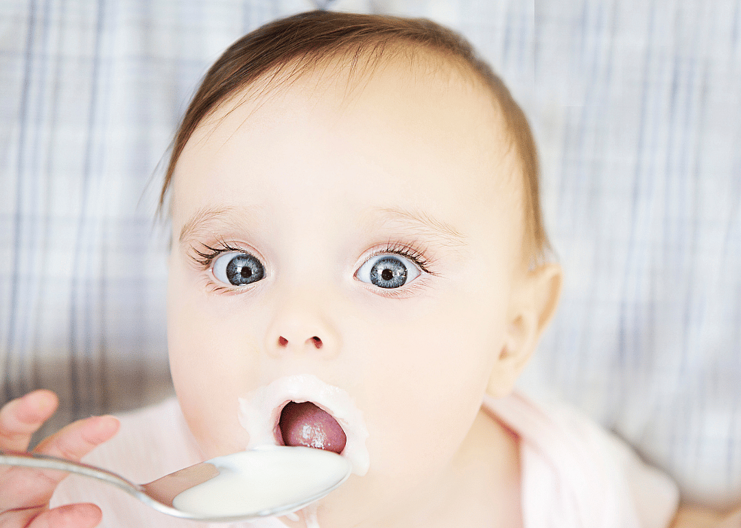 A baby eating yogurt.