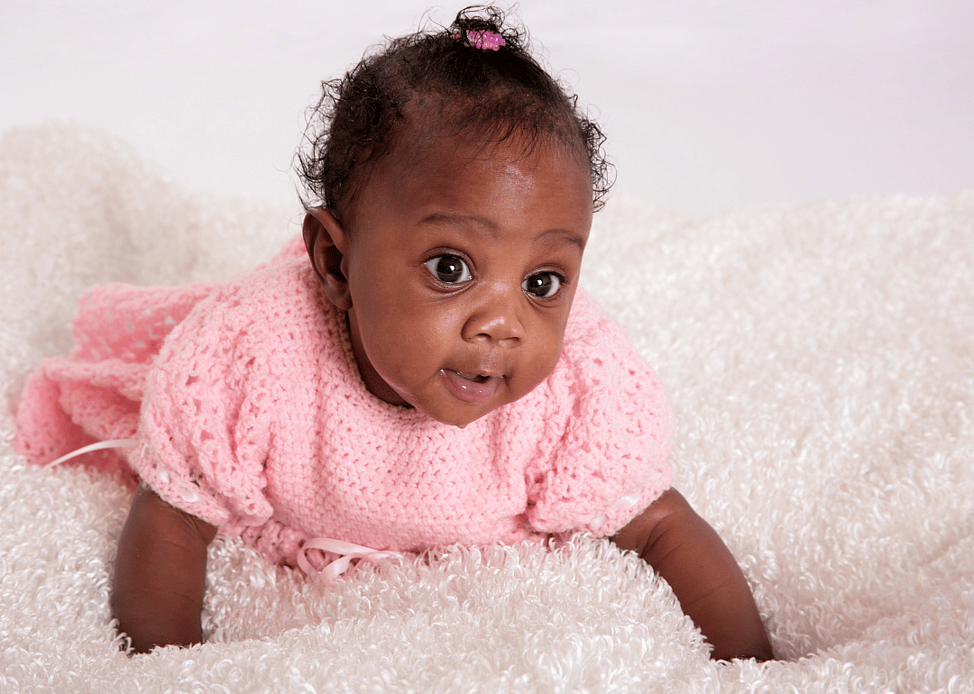 A baby in a pink knitted outfit.