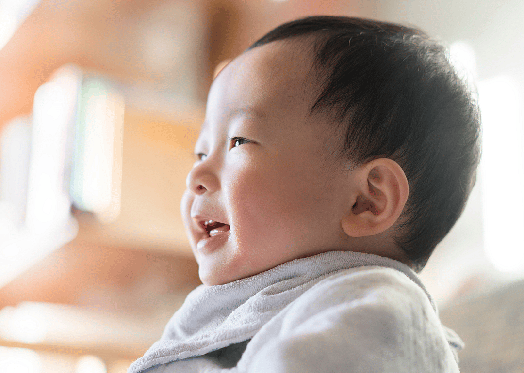 A baby in a bib smiling.