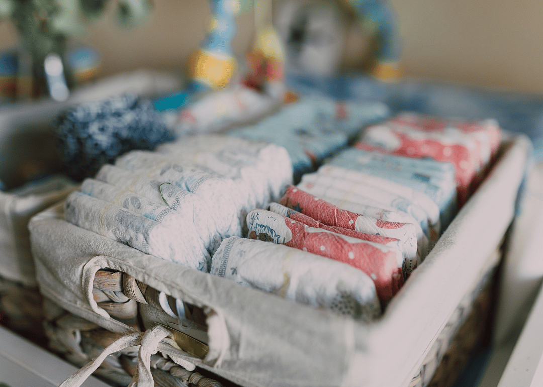 Diapers lined up in a woven basket.