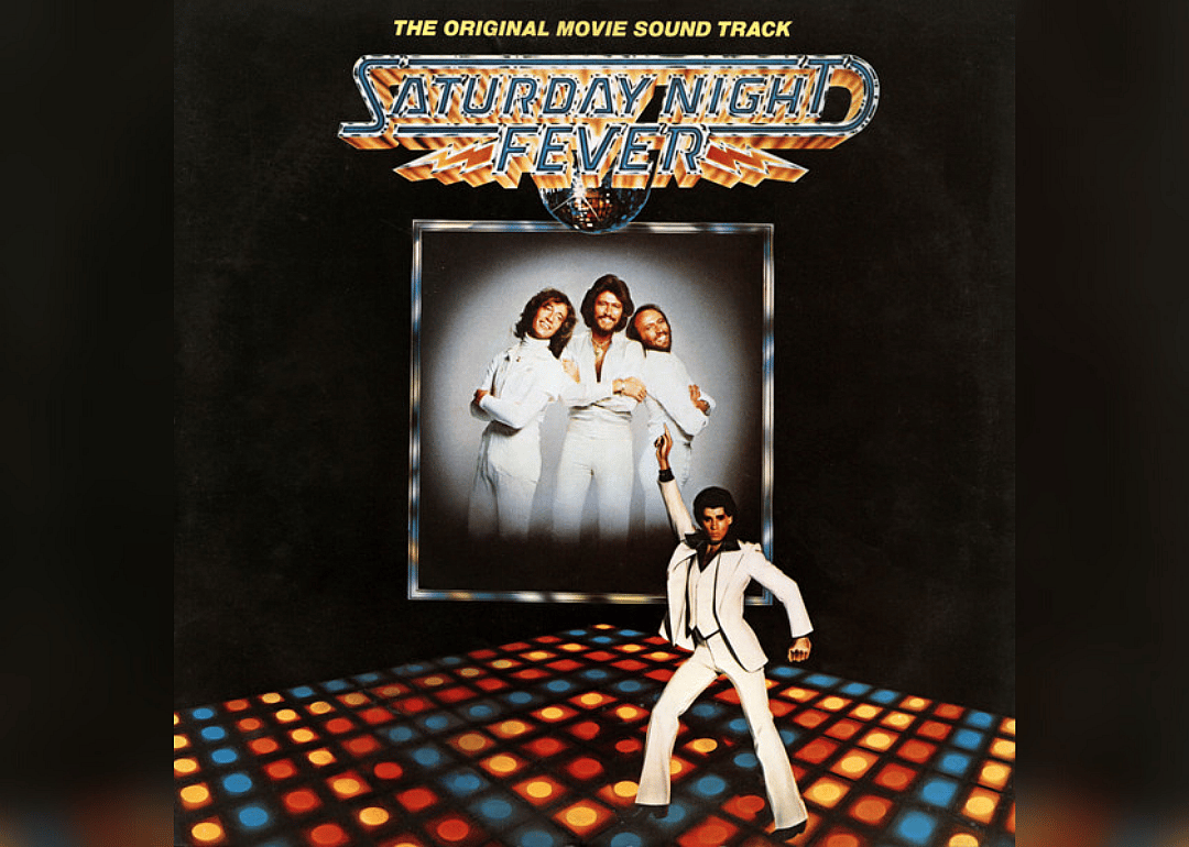 John Travolta on the dancefloor with the Bee Gees in the background.