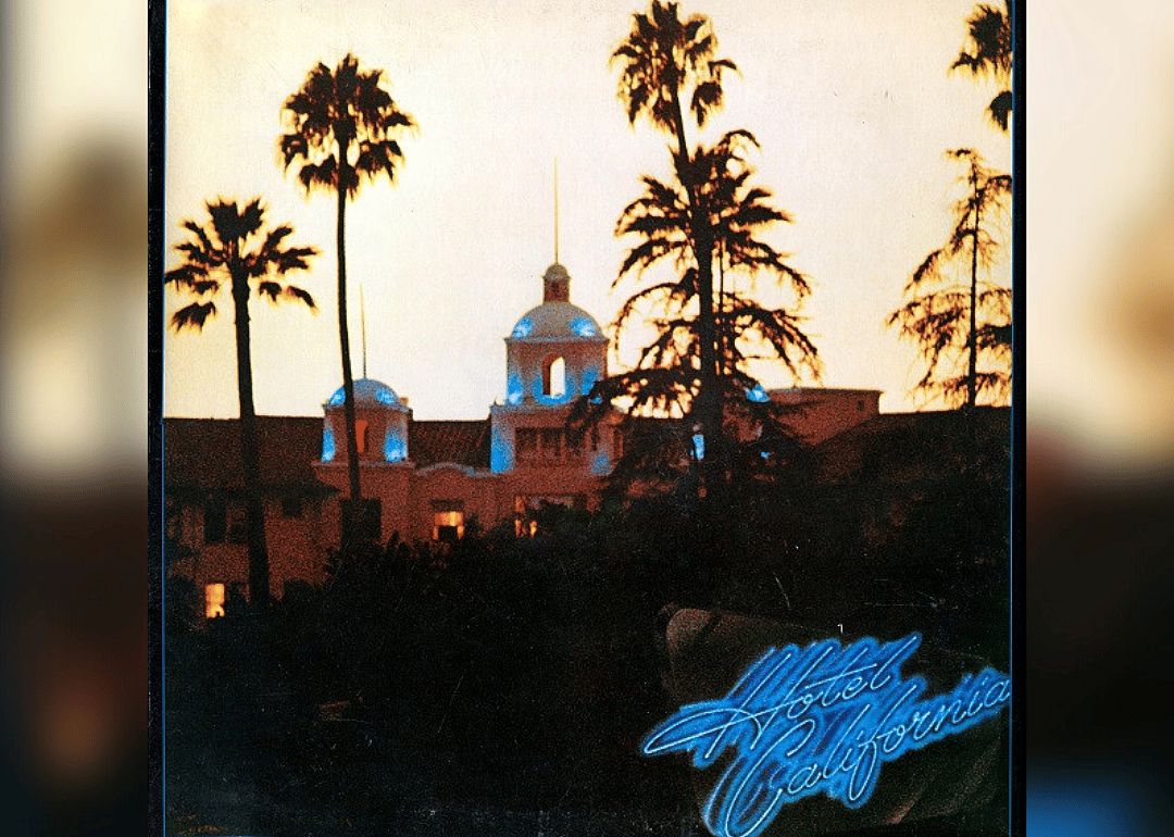 A large hotel with blue neon writing in the corner.