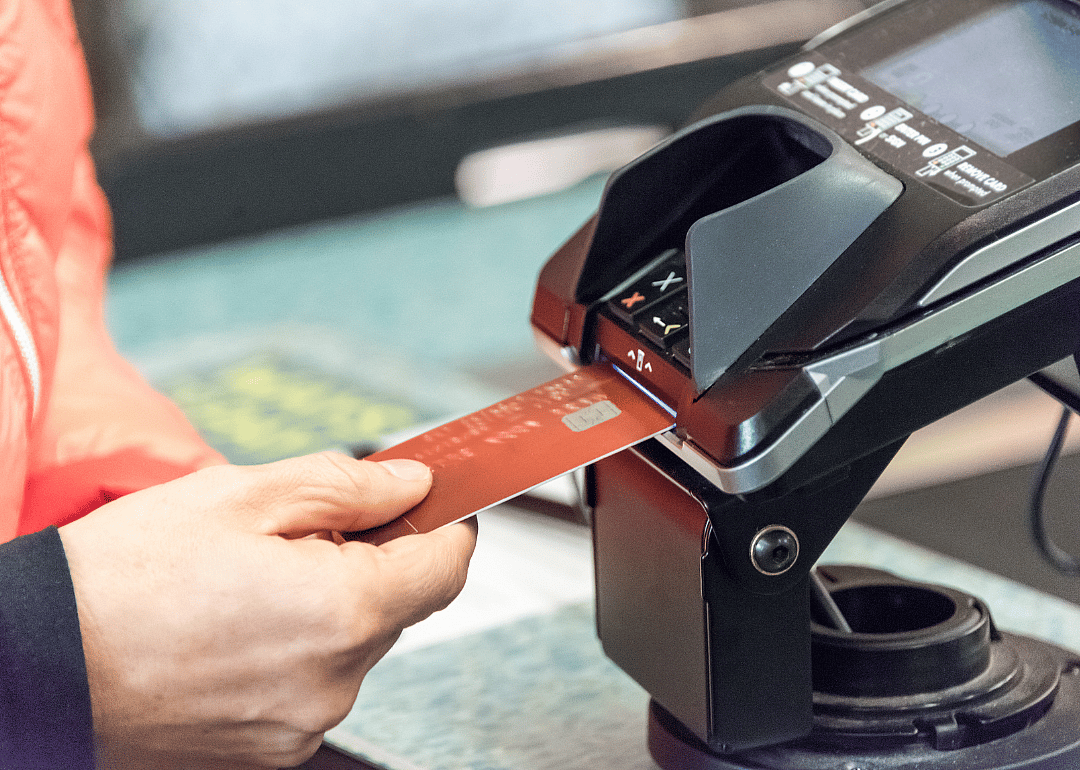 Inserting a credit card into a machine to pay.