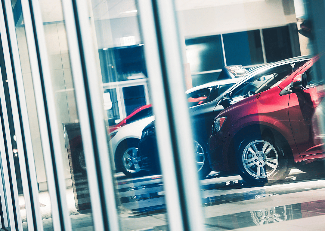 Used vehicles through showroom window.
