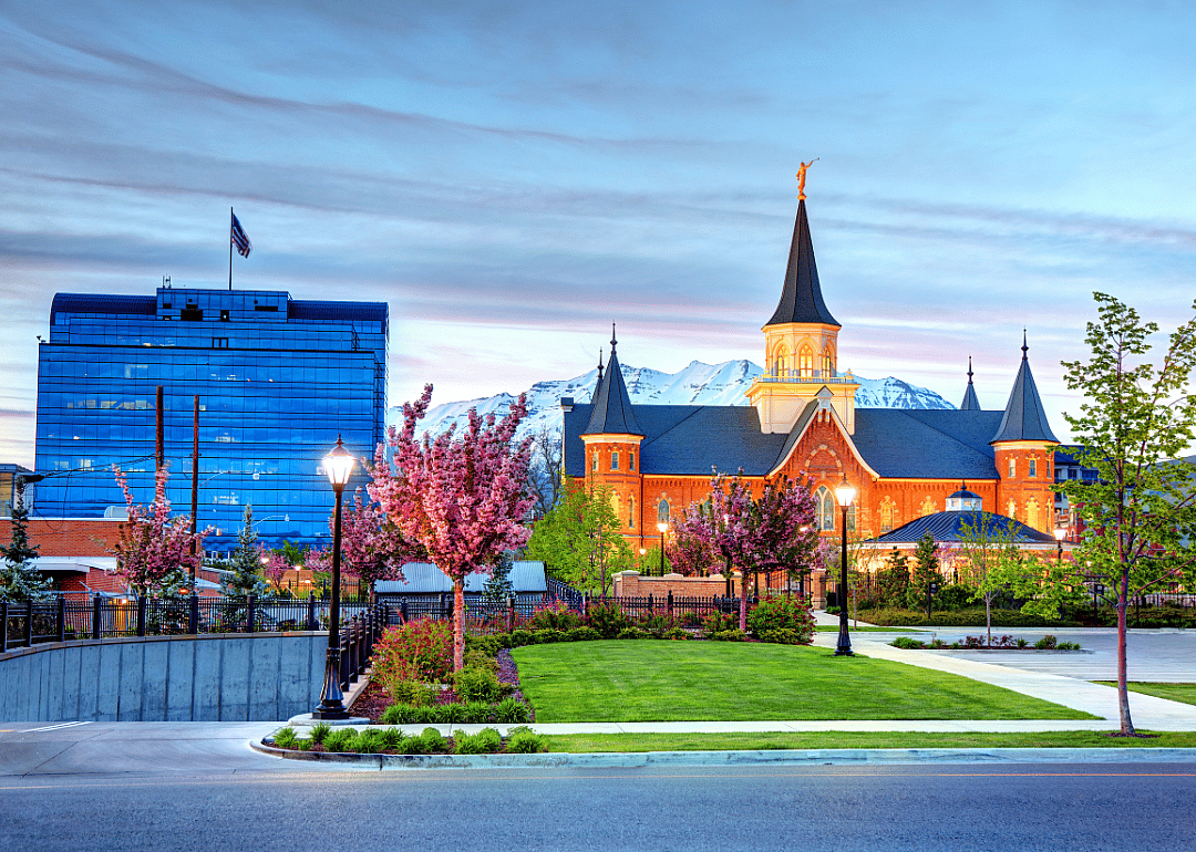 A modern and a historic building in Provo in front of snowy mountains.