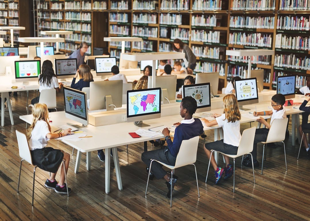 A class full of young students working at desktop computers.