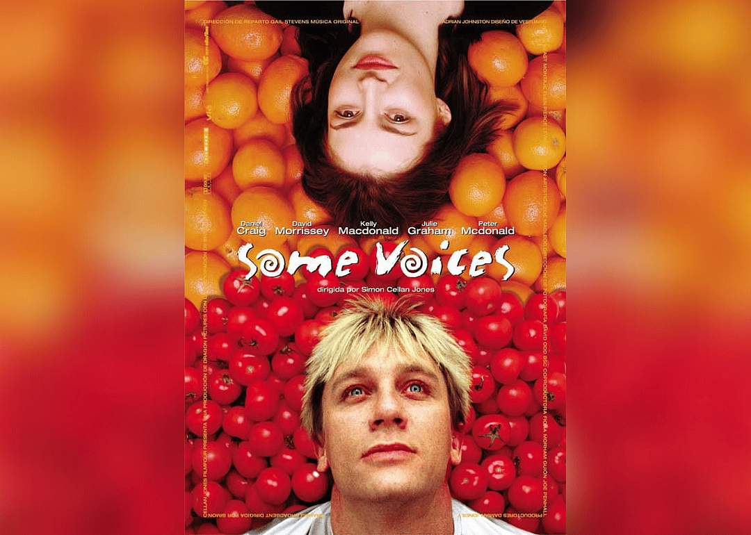 Daniel Craig and Kelly Macdonald lying down on a bed of oranges and tomatoes.