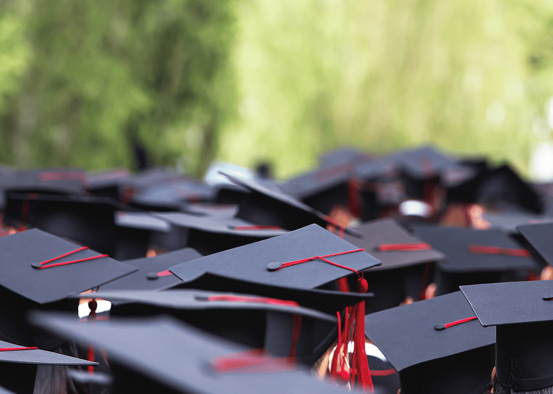 Students graduating in black caps and gowns.