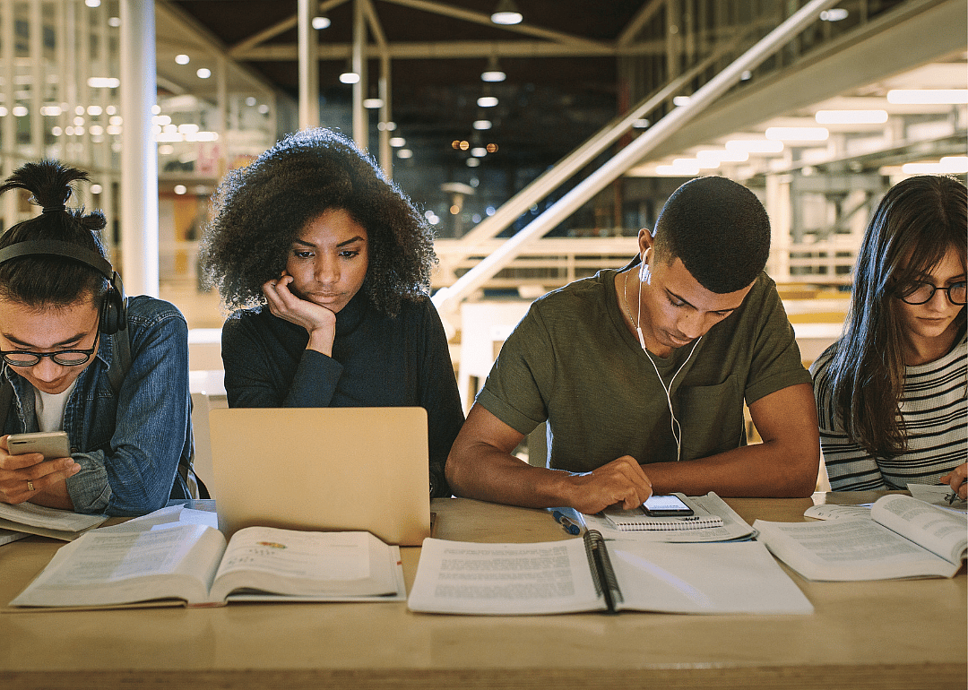 Students sitting at a library table studying.