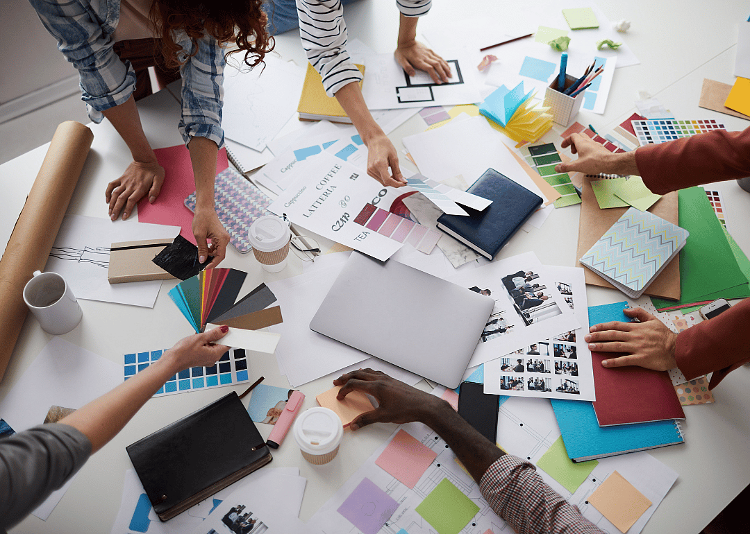 Design students working togther with color palettes and images on a table.