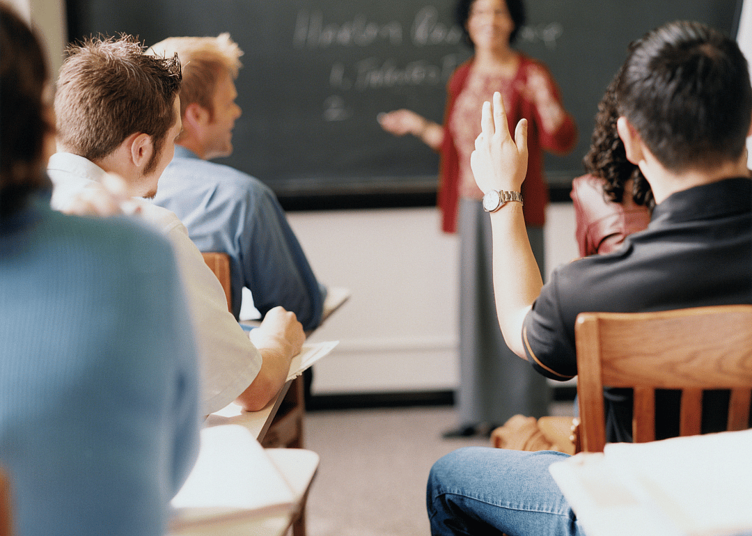 A college student raising his hand during a full class