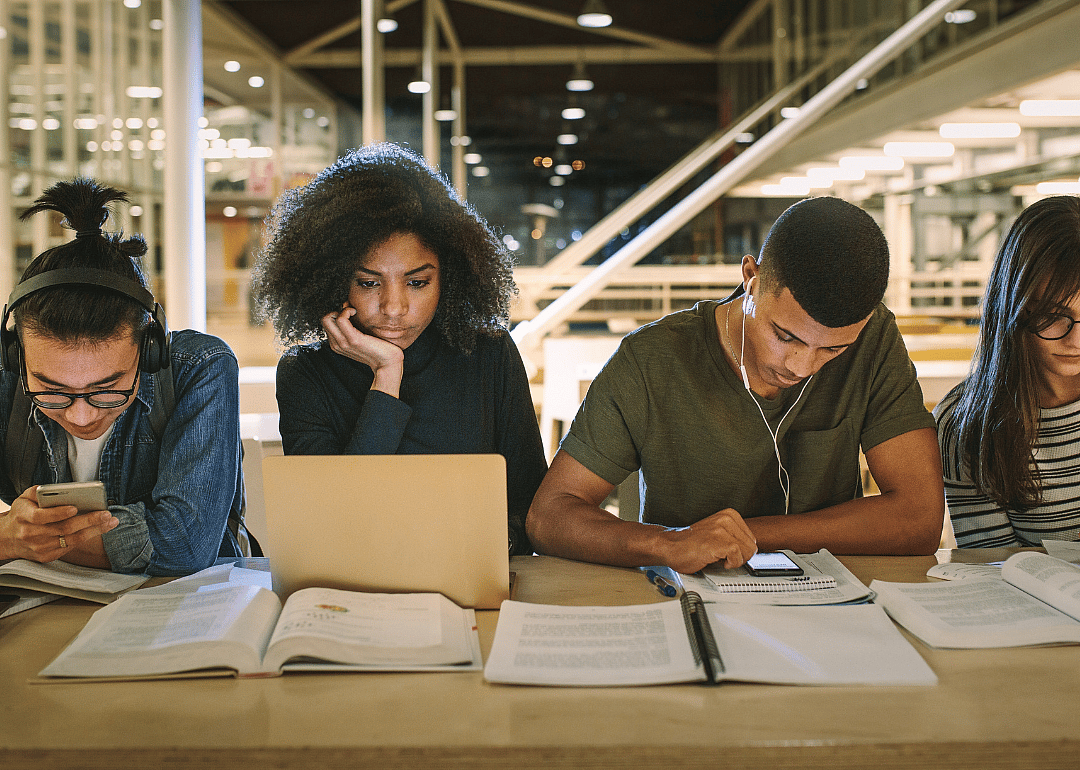 A row of students studyig at a library