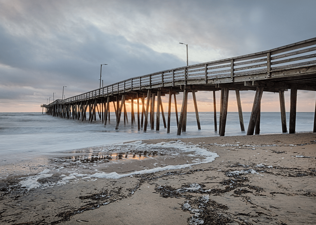 A long wooden boardwalk at sunset. 