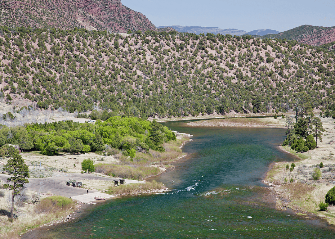 A narrow river runs through mountains. 
