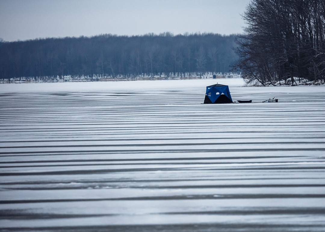A small blue tent on a frozen lake. 