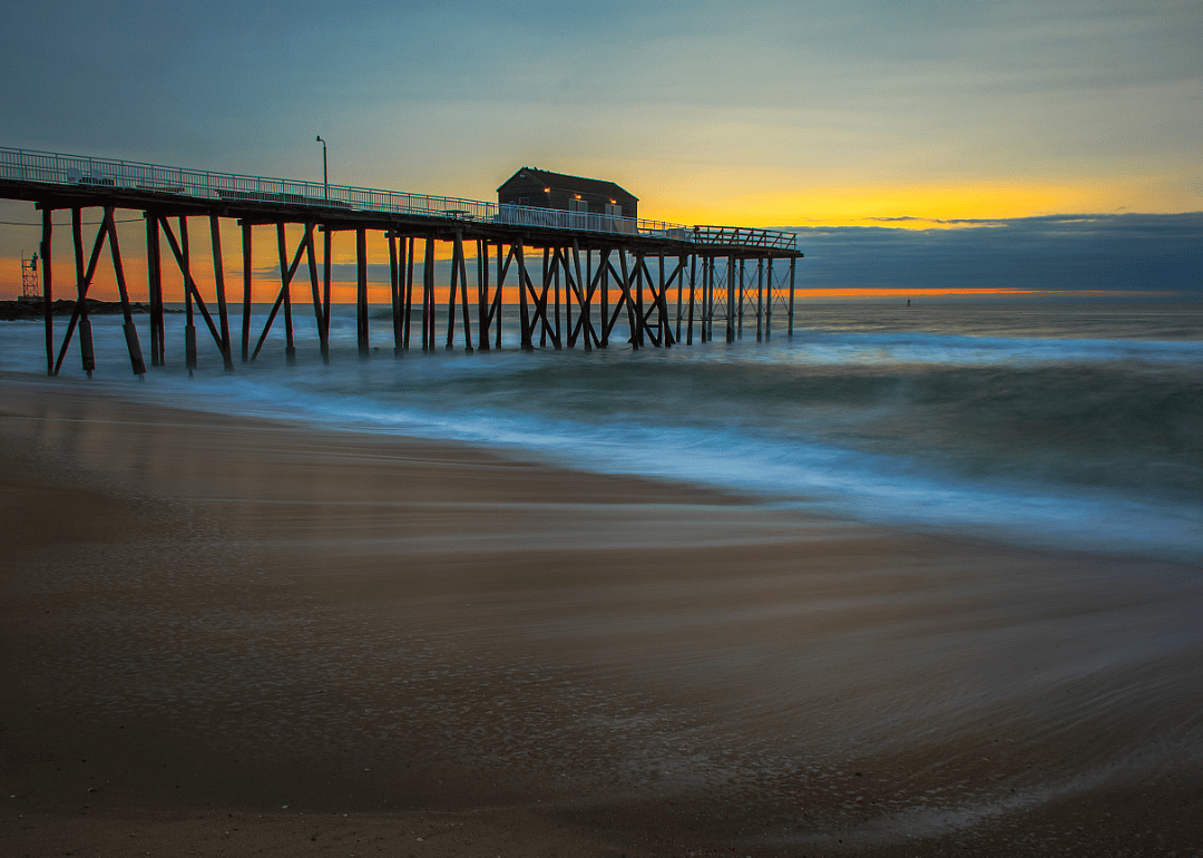 Boardwalk on stilts with the sun setting in the background. 