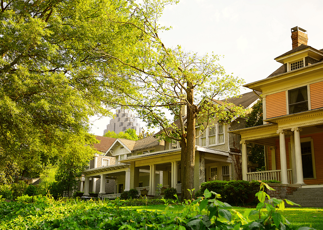 Historic Two-story homes with a skyscraper in the background.