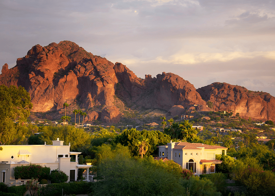 Large stucco homes in the hills with a mountain in the background.