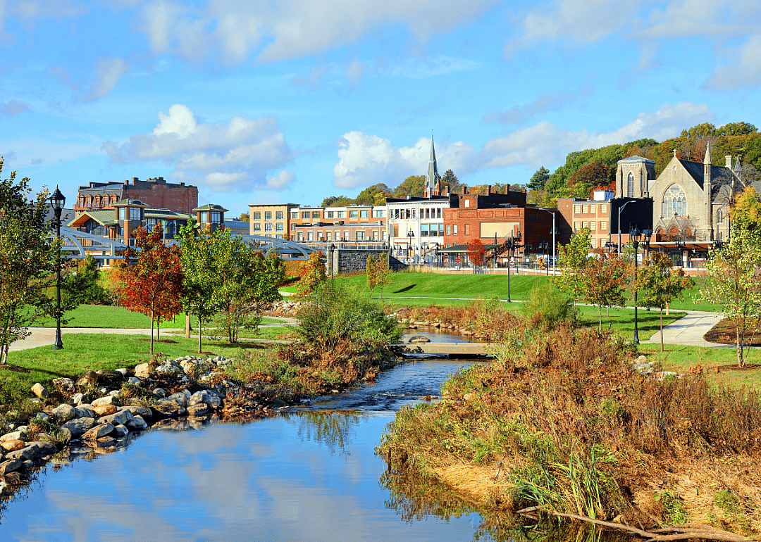 A winding stream flowing around historic buildings in Meriden.