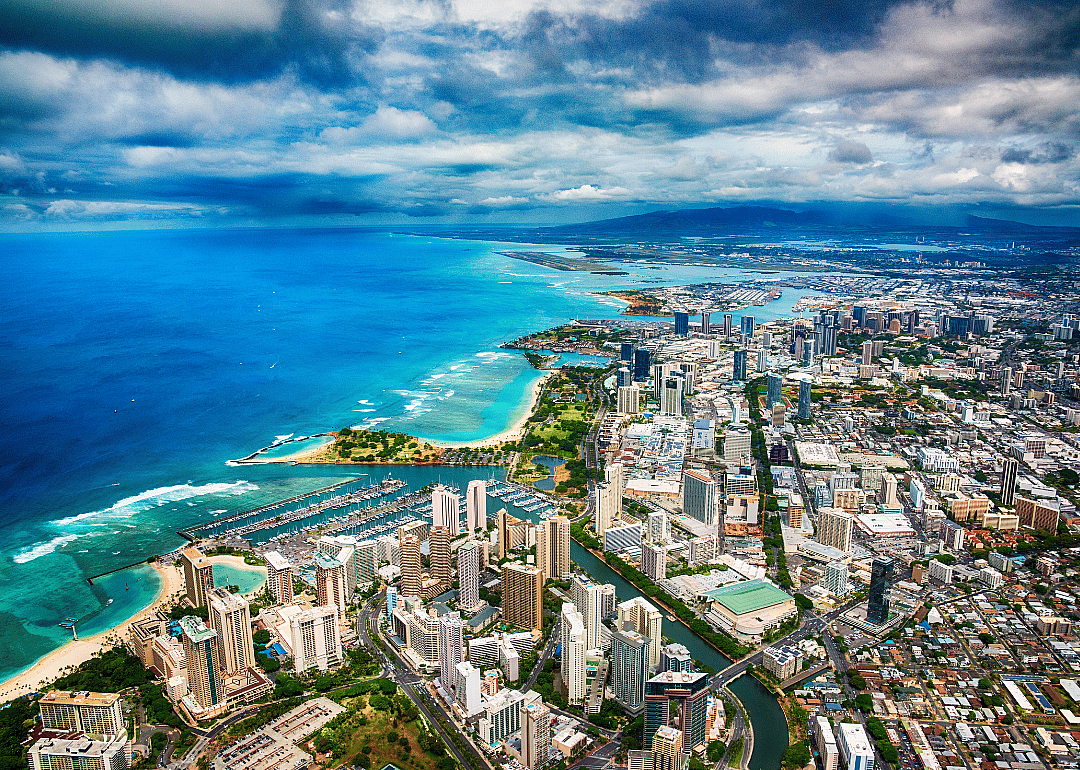 An aerial view of downtown Honolulu next to turquoise water.