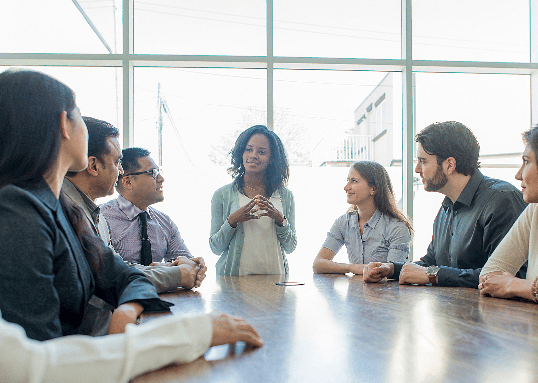 A group of people sit at a table having a meeting.