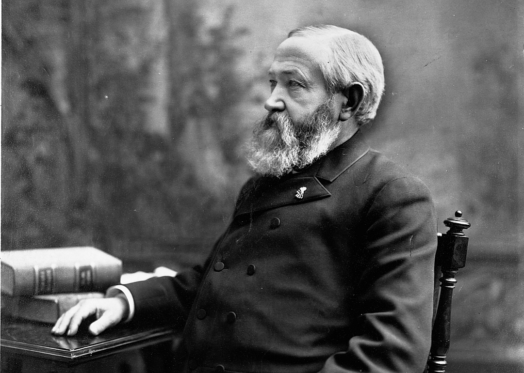 Benjamin Harrison sitting at a desk in a dark suit.