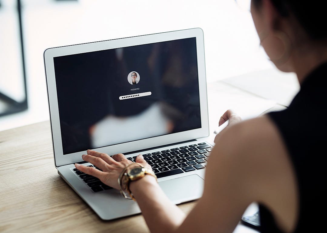 A woman logging into her computer with a password.
