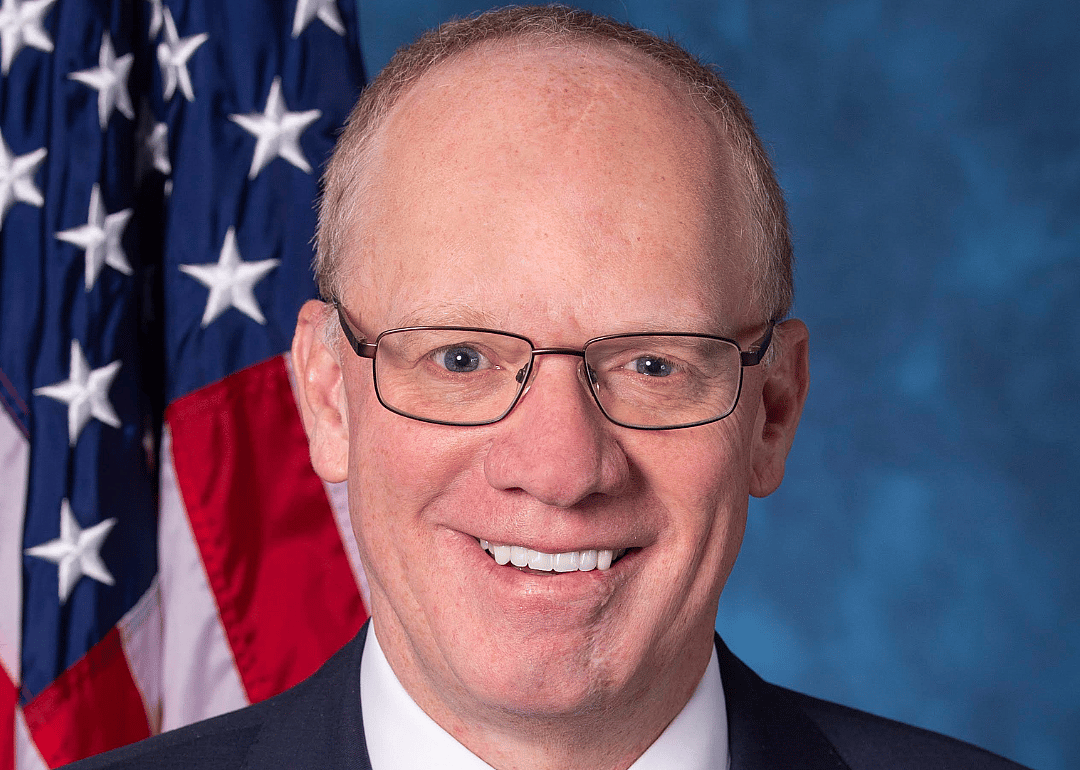 John W. Rose in a blue suit and red tie.