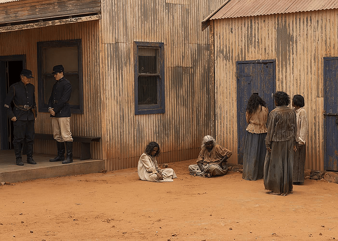 Soldiers standing next to an Aboriginal family.