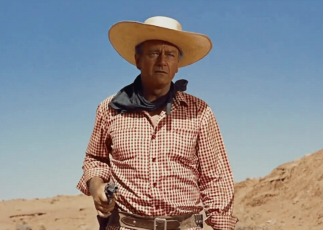 John Wayne in a red and white gingham shirt and bandana.