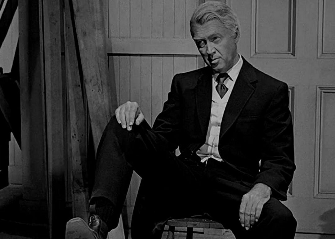 A man in a black suit and cowboy boots.