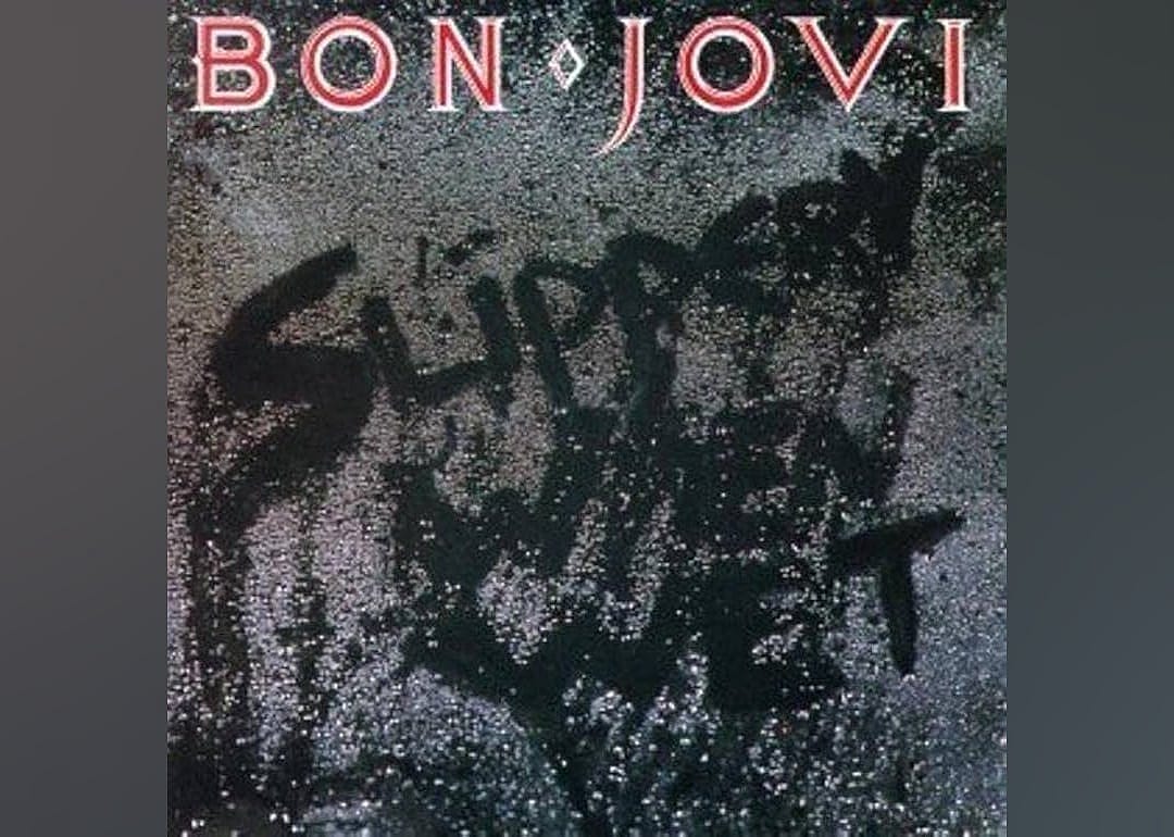 The words 'Slippery When Wet' appear on a sidewalk for Bon Jovi's album cover.