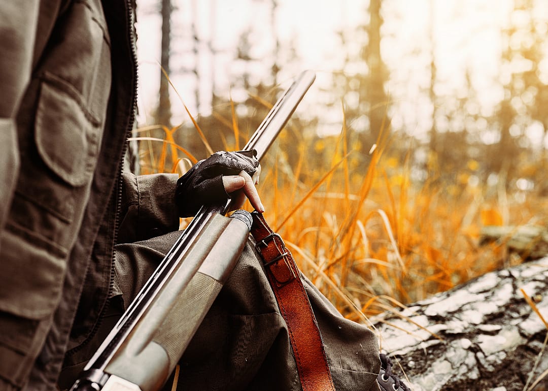 Close up of a rifle in a hunter's hand.