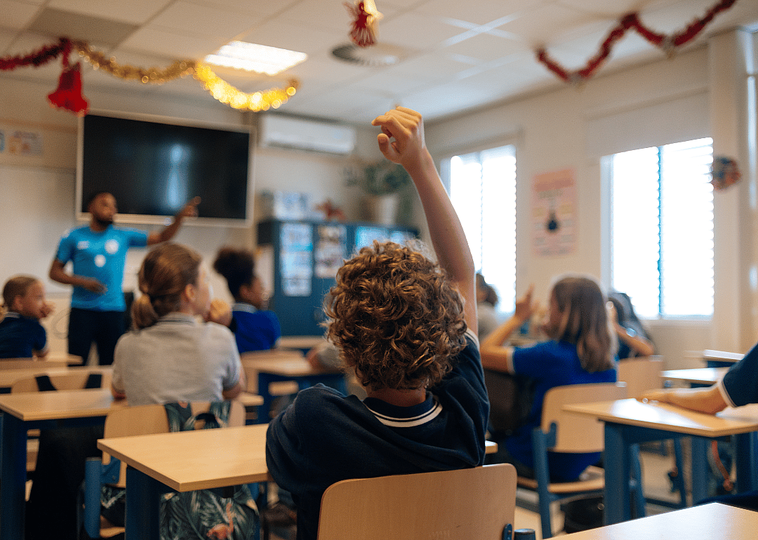Older elementary-aged students in a classroom.