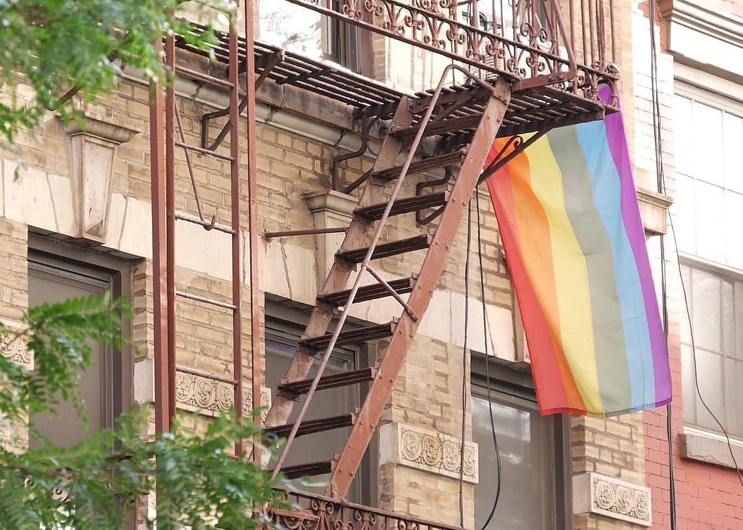 A rainbow flag flying outside of an apartment building in Manhattan, New York.