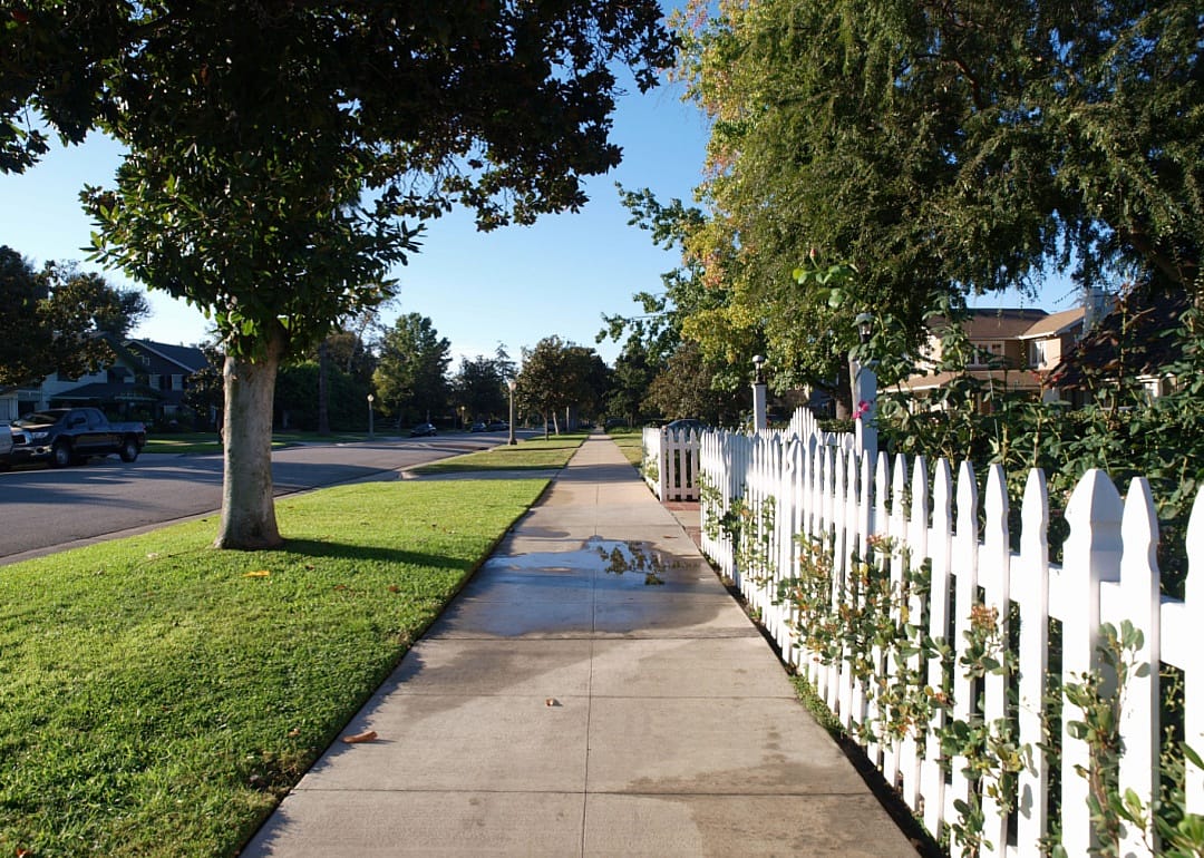 A white picket fence on a residential street.