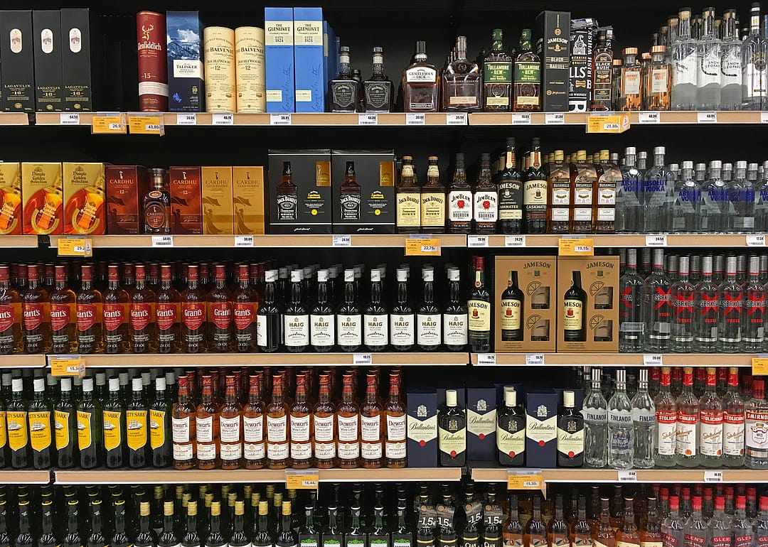 Whisky and vodka bottles on display at a liquor store
