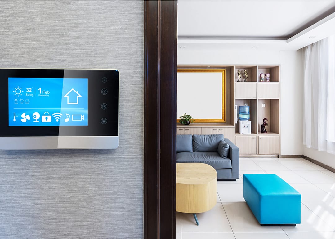 A touch screen open to a smart home app controlling a modern living room