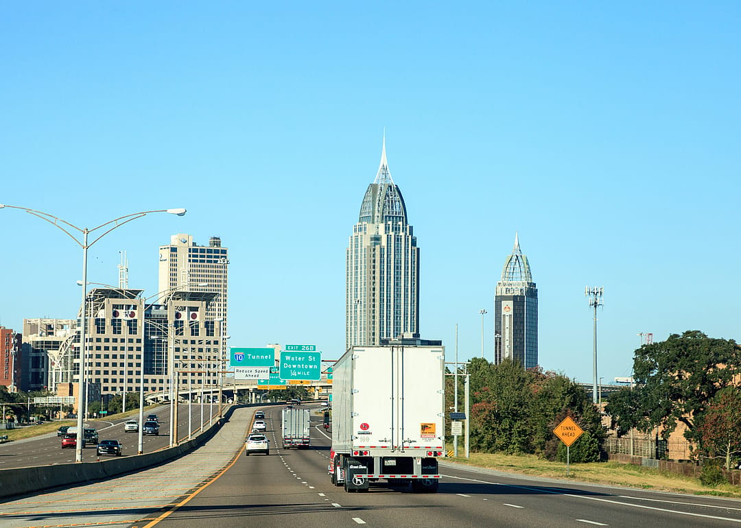 Cars driving on a highway leading into downtown Mobile, Alabama.