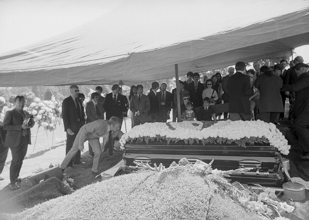 McQueen straightens the sign on casket at Bruce Lee's funeral.