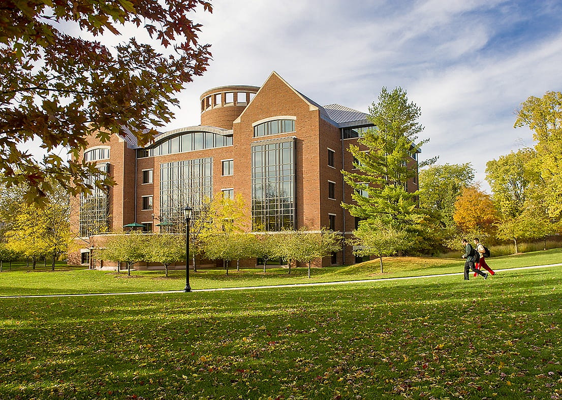 A large brick library with glass windows in the front.