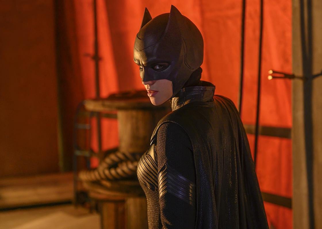Batwoman in front of a red background.