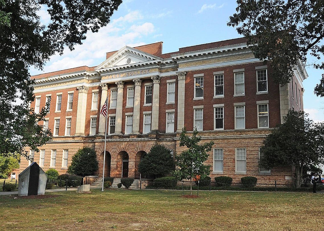 A historic red brick building with columns.